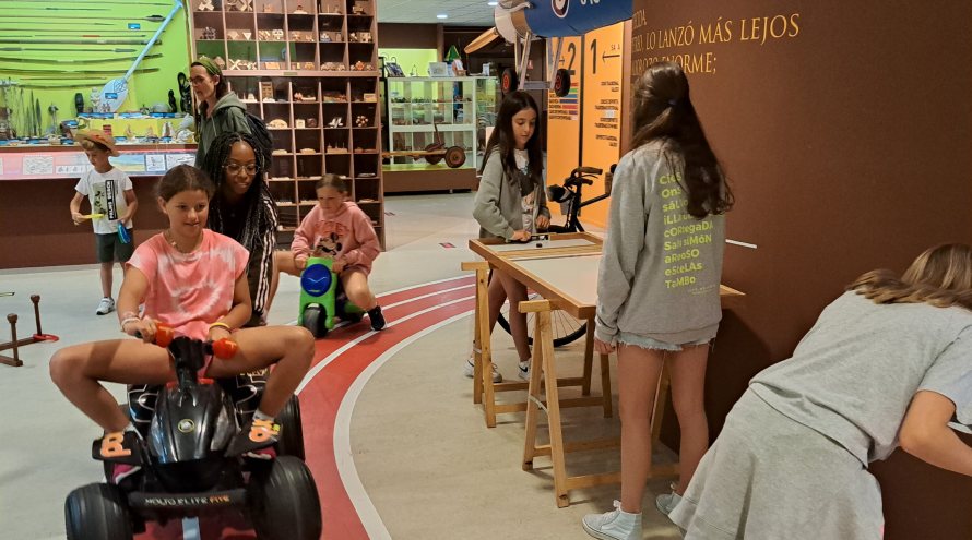 Jóvenes jugando en el museo melga a un juego tradicional