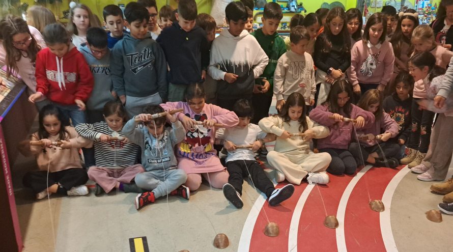 Varios alumnos del CEIP A Cristina juegan a juegos populares mientras el resto los observa.