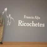 Ricardo Pérez y Verdes posa frente al cartel de Ricochetes de Frencis Alÿs